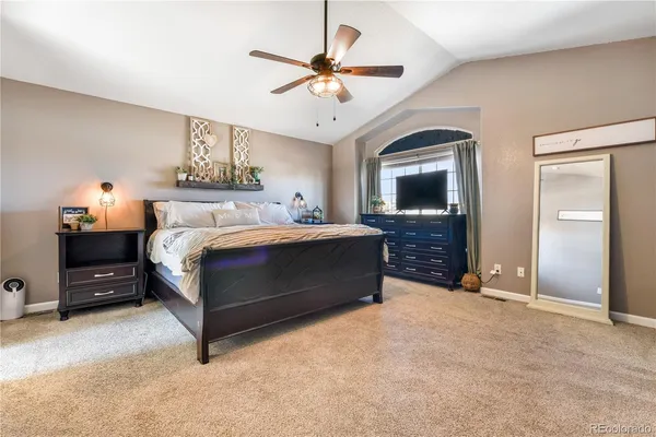 a bedroom with a bed and a ceiling fan