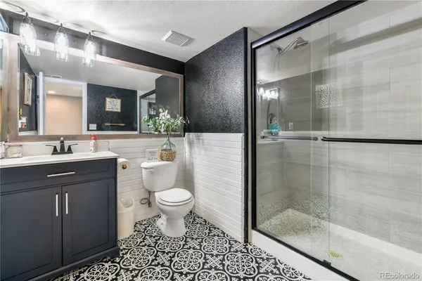 a bathroom with a sink a toilet and shower