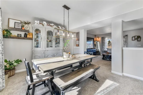 a living room with furniture a chandelier and a dining table