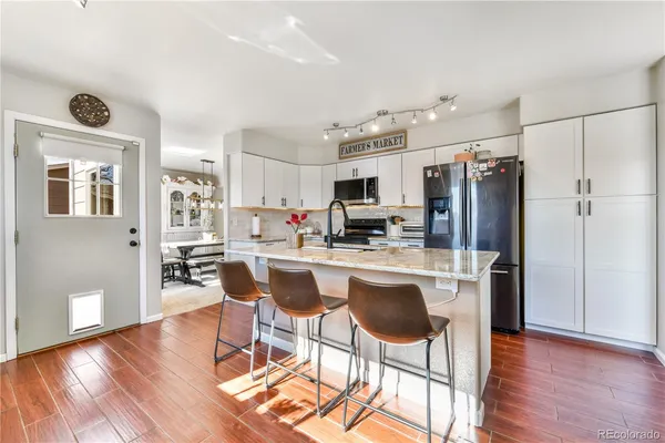 a kitchen with stainless steel appliances granite countertop a refrigerator and a stove top oven