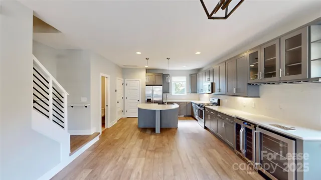 a open kitchen with stainless steel appliances granite countertop a lot of counter space and wooden floor