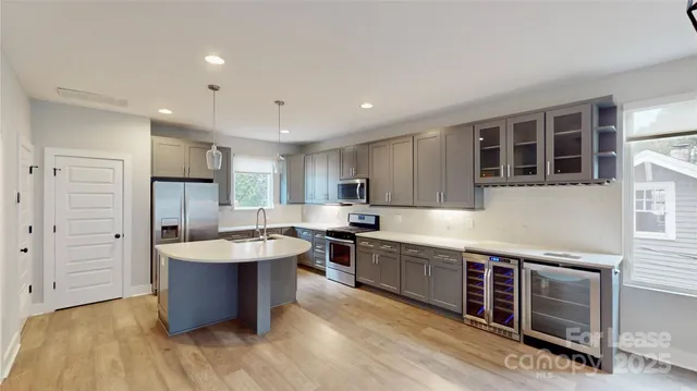 a large kitchen with stainless steel appliances granite countertop a lot of counter space and wooden floors