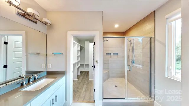 a bathroom with a shower sink and mirror