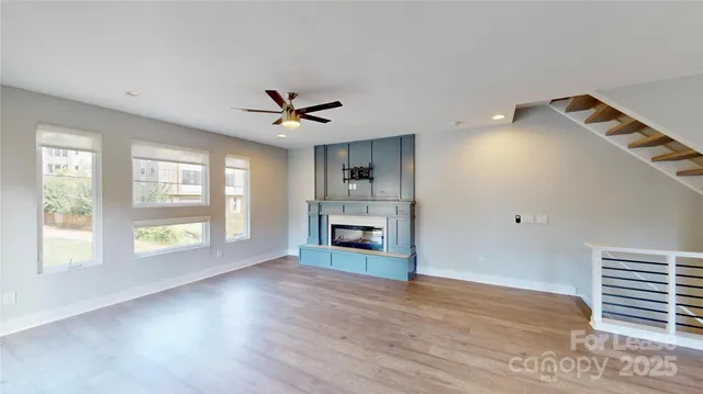 a view of an empty room with a window and fireplace