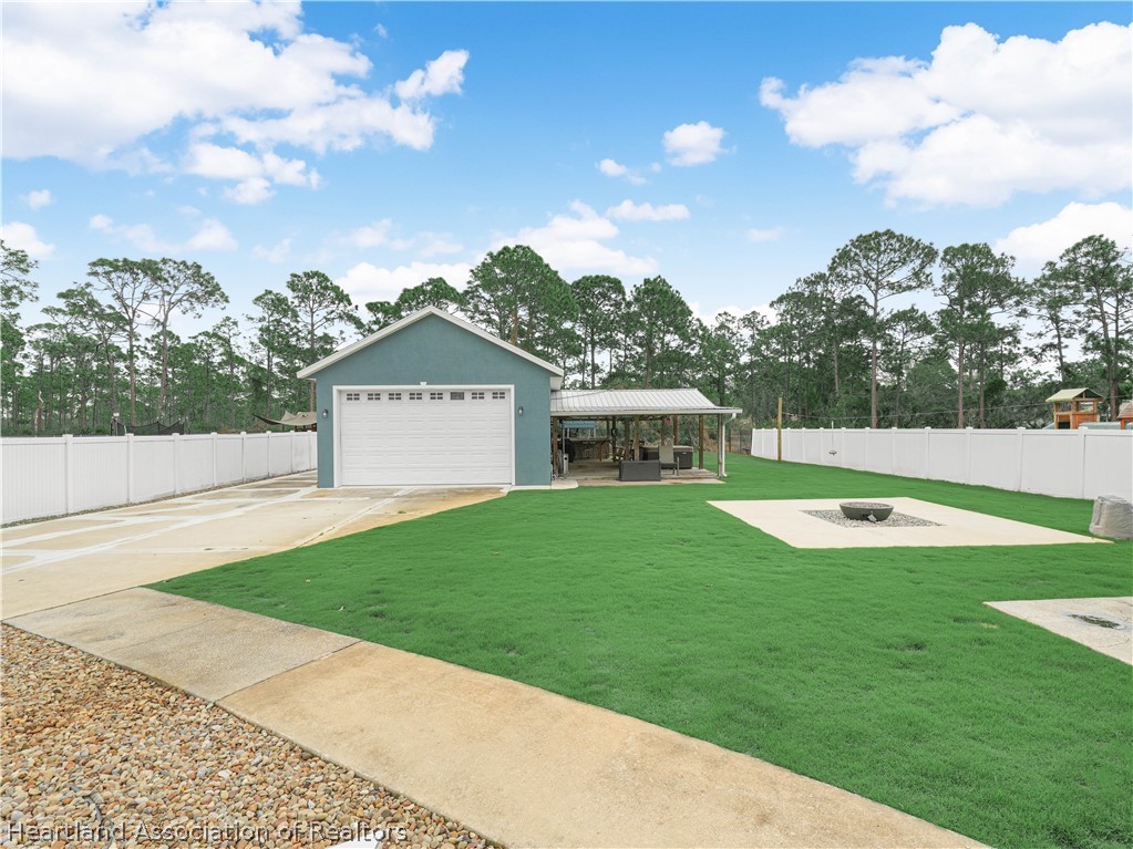 5430 Lakewood Road Sebring, FL 33875 - Photo 27 of 40 Backyard with view of Workshop, Covered Deck w/hot-tub & firepit w/seating area