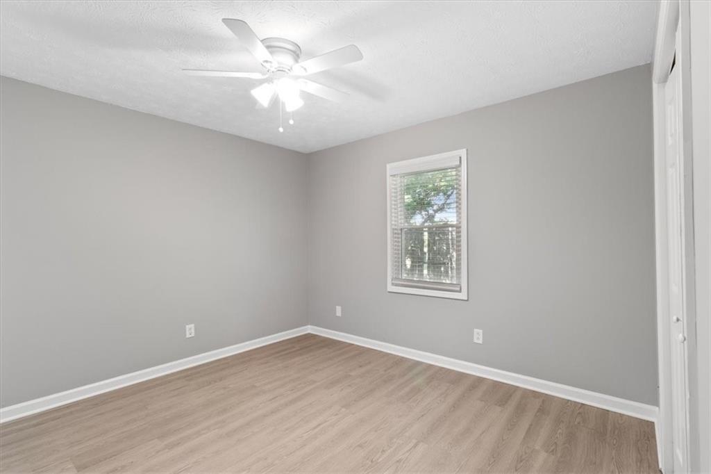 894 Five Forks Trickum Road Southwest Lawrenceville, GA 30046 - Photo 14 of 28 an empty room with wooden floor and windows