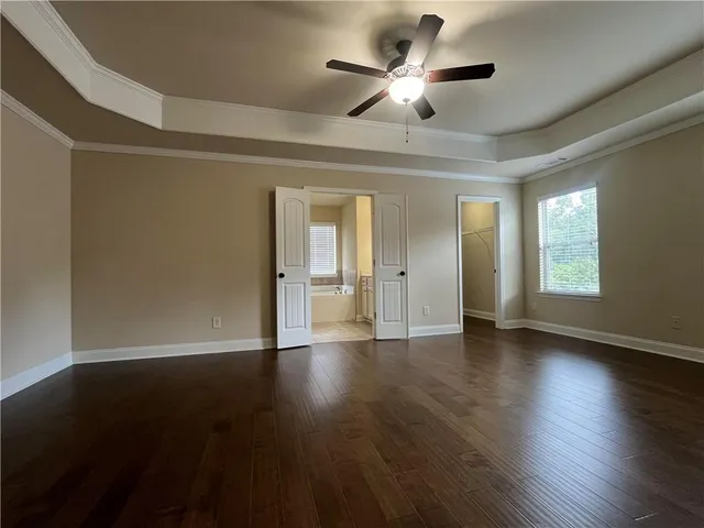 a view of an empty room with a window and wooden floor