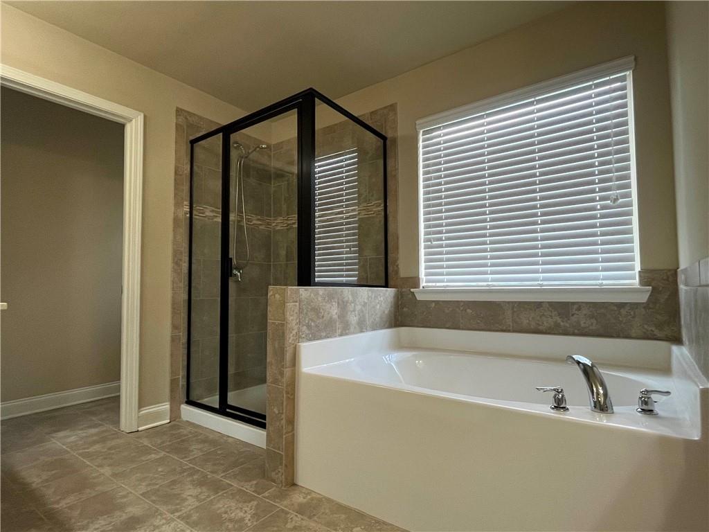 2299 Misty Ivy Court Buford, GA 30519 - Photo 15 of 26 a bathroom with a bathtub and a shower