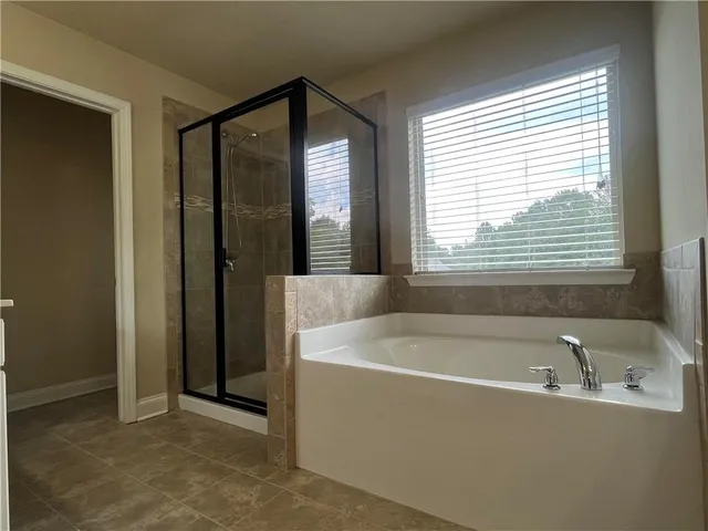 a white bath tub sitting in a bathroom next to a window