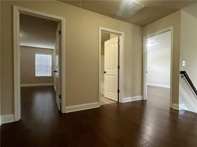 an empty room with wooden floor and closet