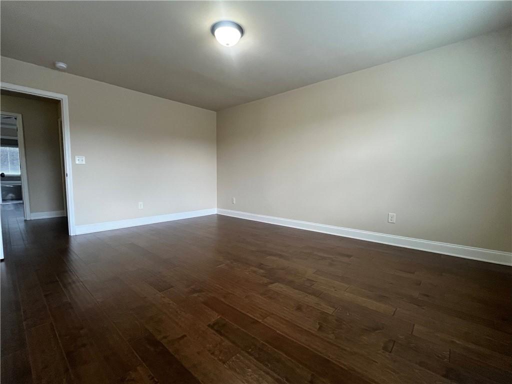 2299 Misty Ivy Court Buford, GA 30519 - Photo 23 of 26 an empty room with wooden floor and windows