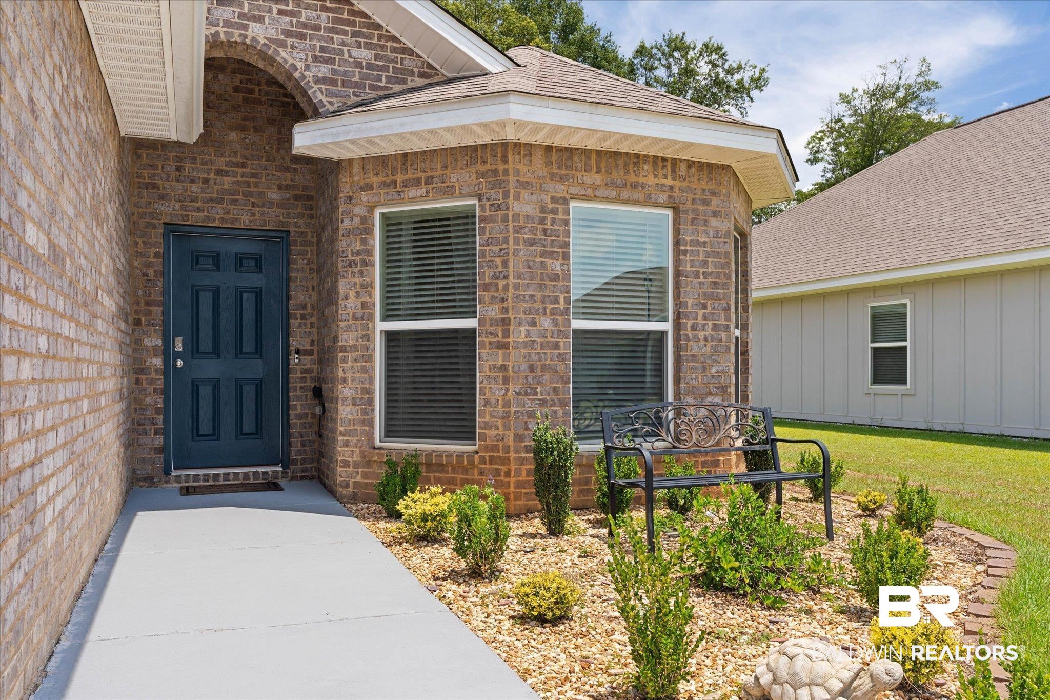 9037 Impala Drive Foley, AL 36535 - Photo 16 of 21 View of exterior entry featuring brick siding and a lawn