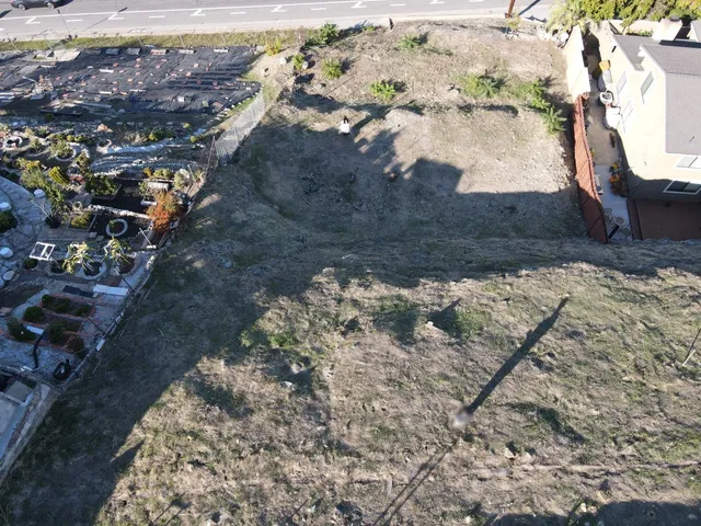 a view of a yard with wooden fence