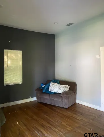 a living room with hard wood floor and a table