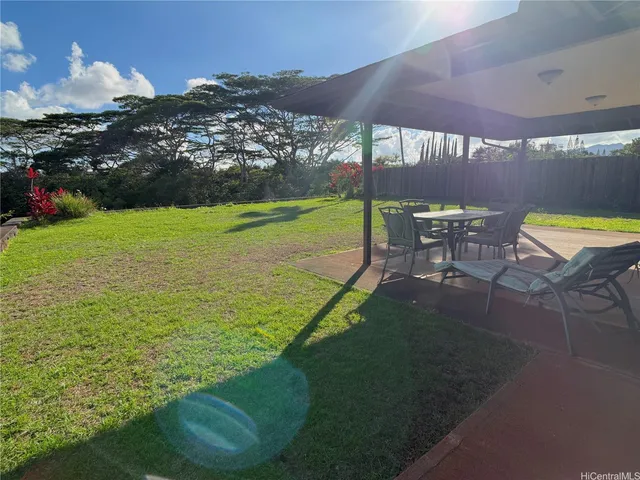 a view of a swimming pool with lawn chairs under an umbrella