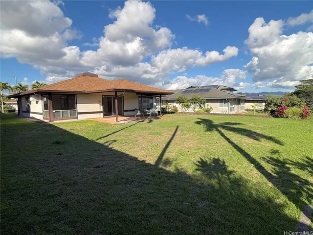 a view of a house with a big yard and a large tree