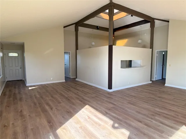 a view of a big room with wooden floor and a bathroom