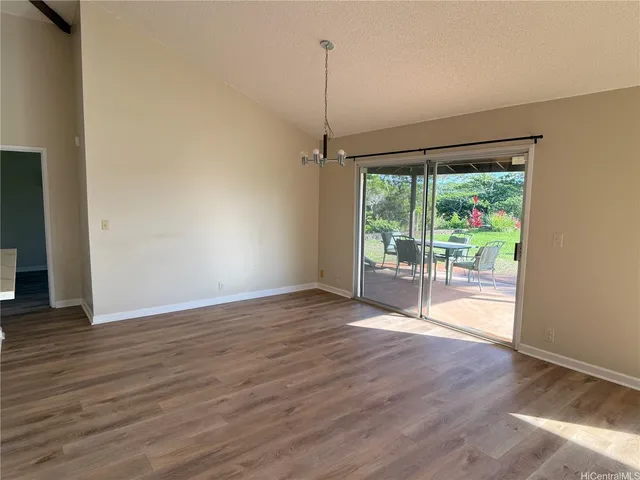 a view of empty room with wooden floor and outdoor space