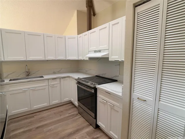 a kitchen with cabinets appliances and a window