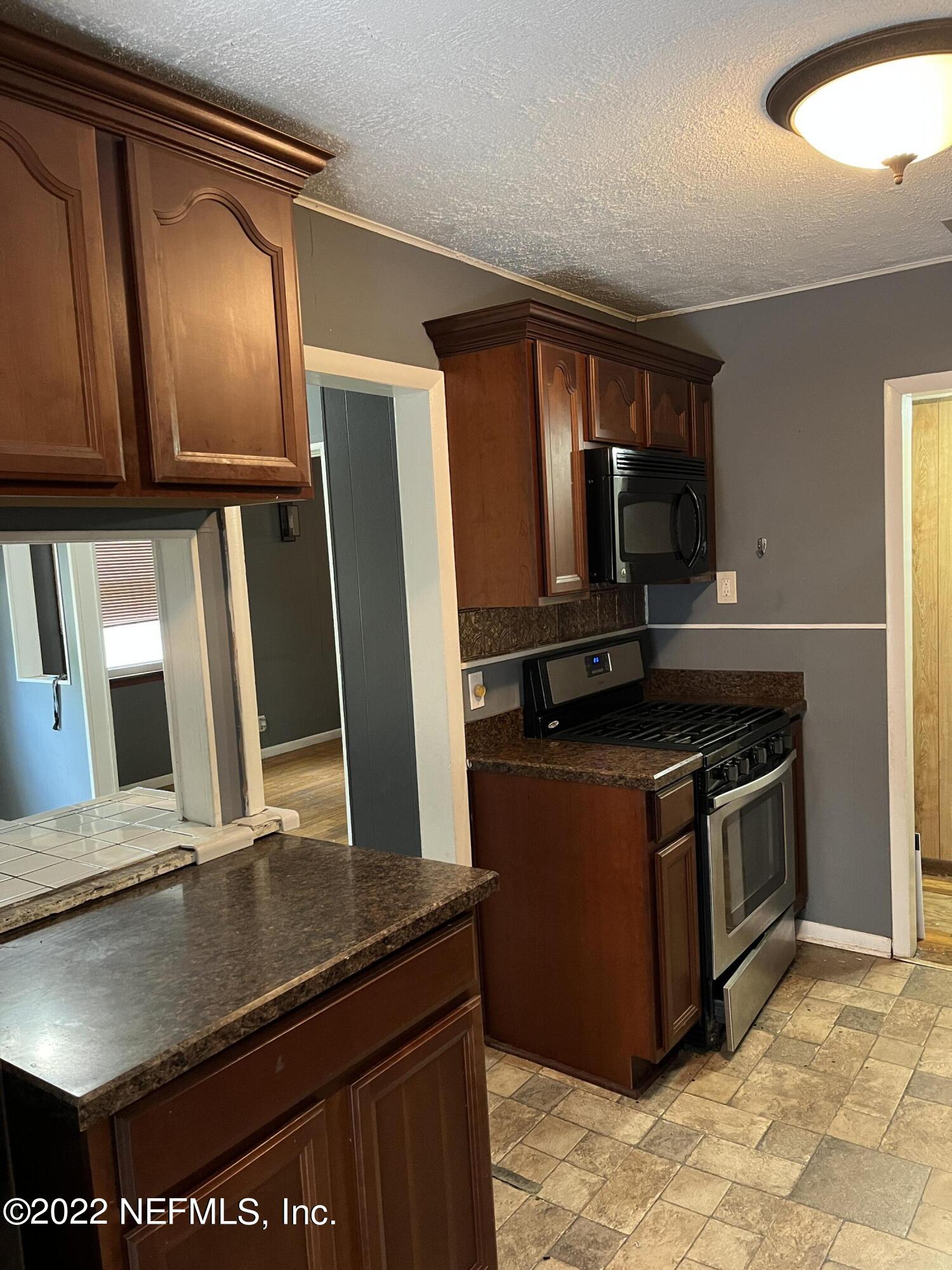 4752 Myrtlewood Road Jacksonville, FL 32210 - Photo 4 of 18 a kitchen with stainless steel appliances granite countertop a stove a sink and a refrigerator