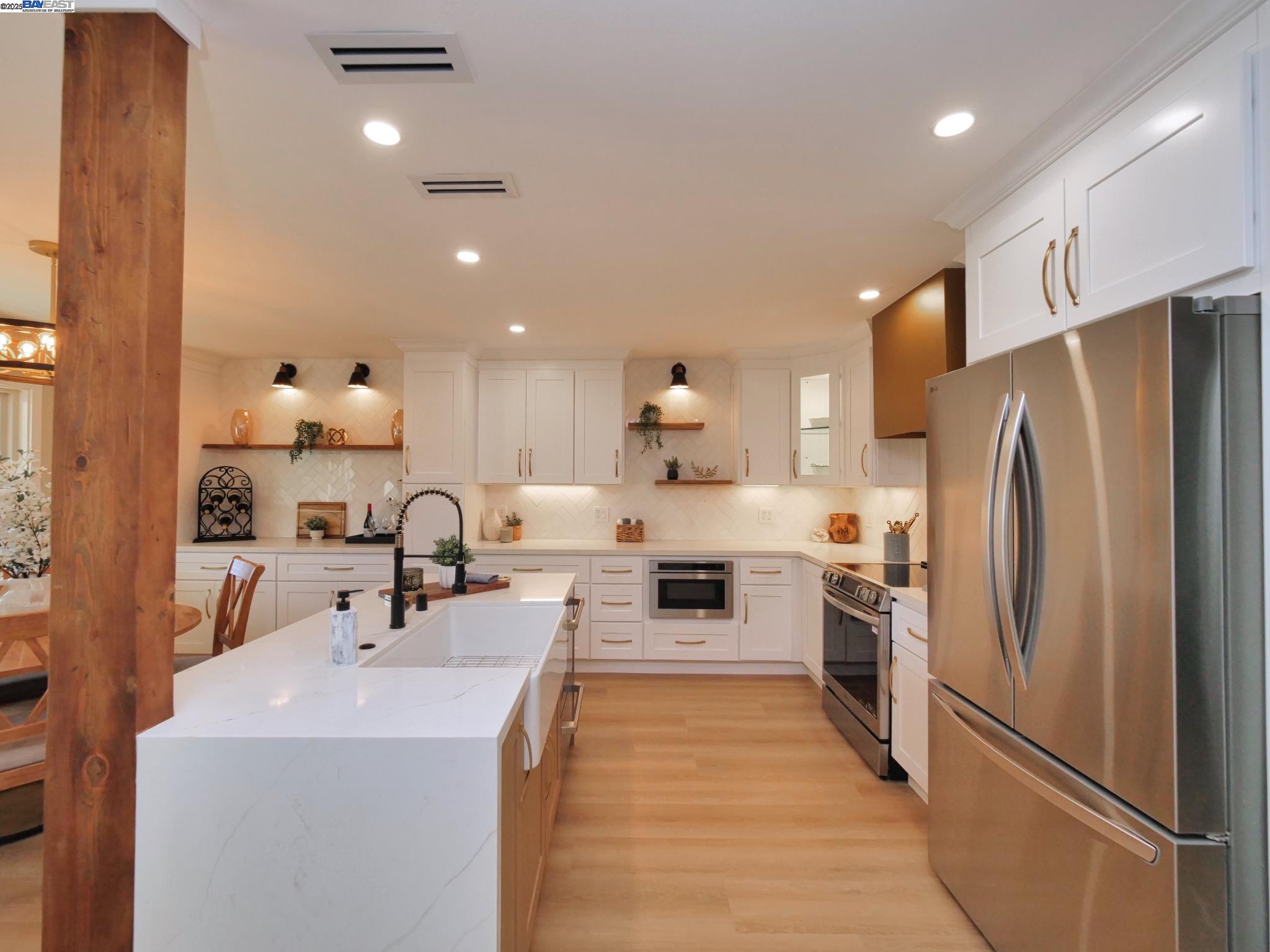 1732 Oakmont Drive, Unit 8 Walnut Creek, CA 94595 - Photo 3 of 23 a kitchen with refrigerator a sink and a stove top oven with wooden floor