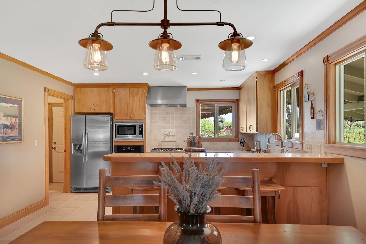 10801 Shenandoah Road Plymouth, CA 95669 - Photo 2 of 45 a kitchen with stainless steel appliances kitchen island granite countertop a refrigerator a stove and a sink with wooden floor