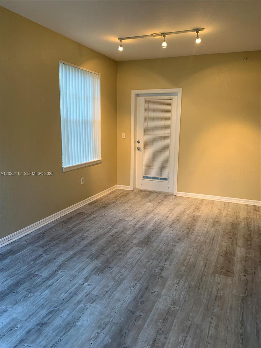 6572 West Sample Road, Unit 6572 Coral Springs, FL 33067 - Photo 14 of 17 a view of an empty room with wooden floor and a window