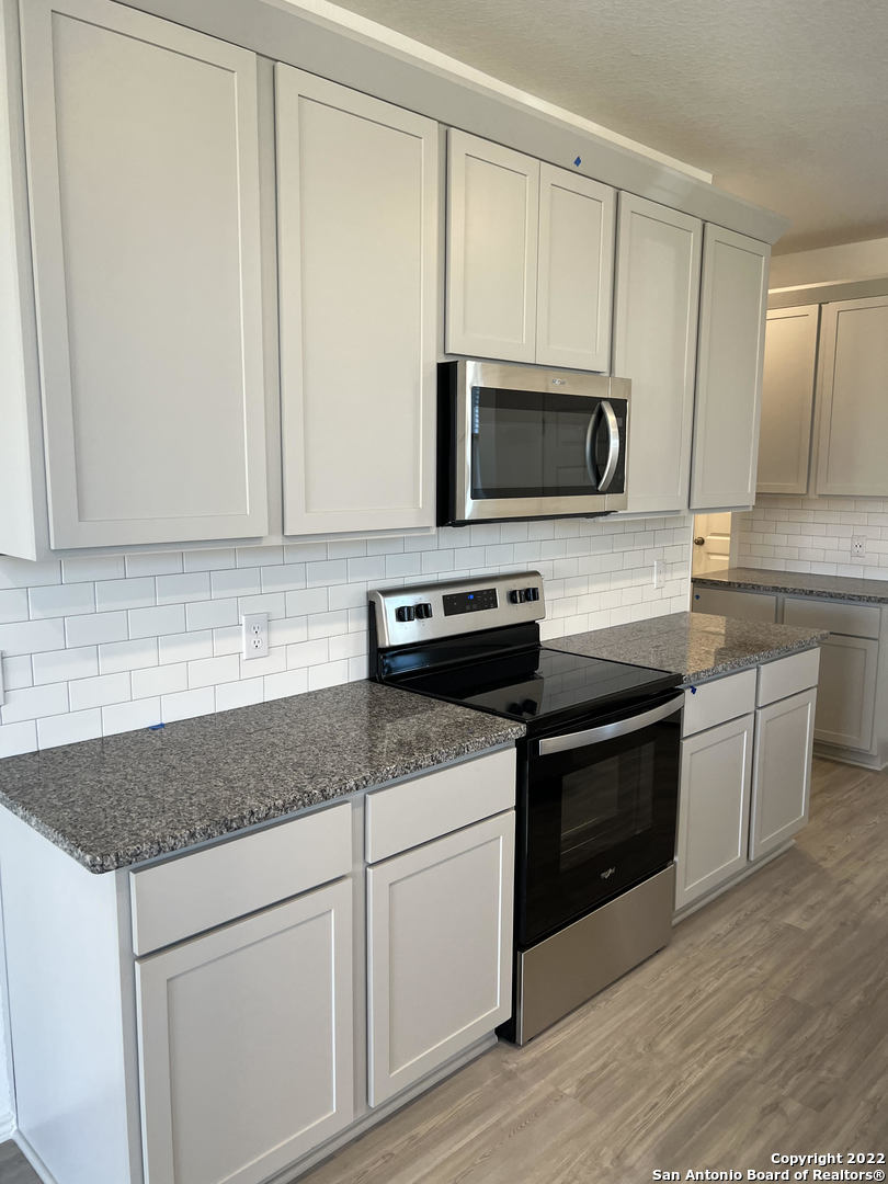 2164 Griffith Drive Seguin, TX 78155 - Photo 8 of 21 a kitchen with granite countertop a sink and steel appliances