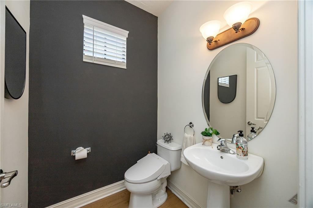 9128 Delano Street, Unit 892 Naples, FL 34113 - Photo 9 of 49 a bathroom with a toilet sink and mirror