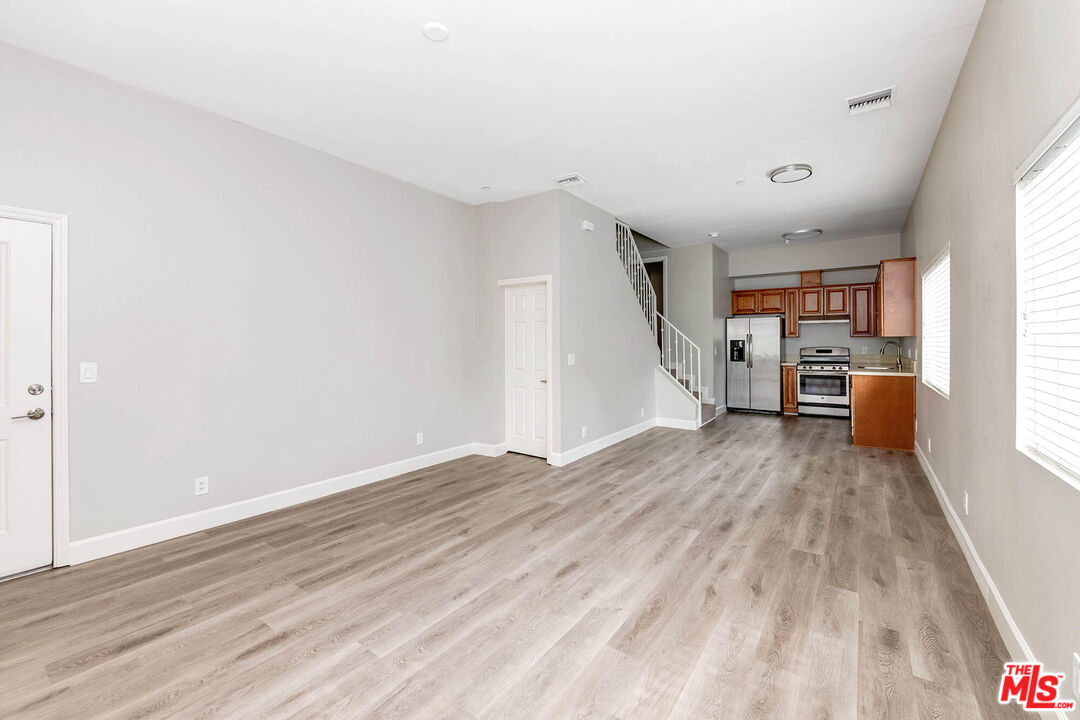 14735 Friar Street, Unit 113 Van Nuys, CA 91411 - Photo 4 of 16 a view of a kitchen with furniture and wooden floor