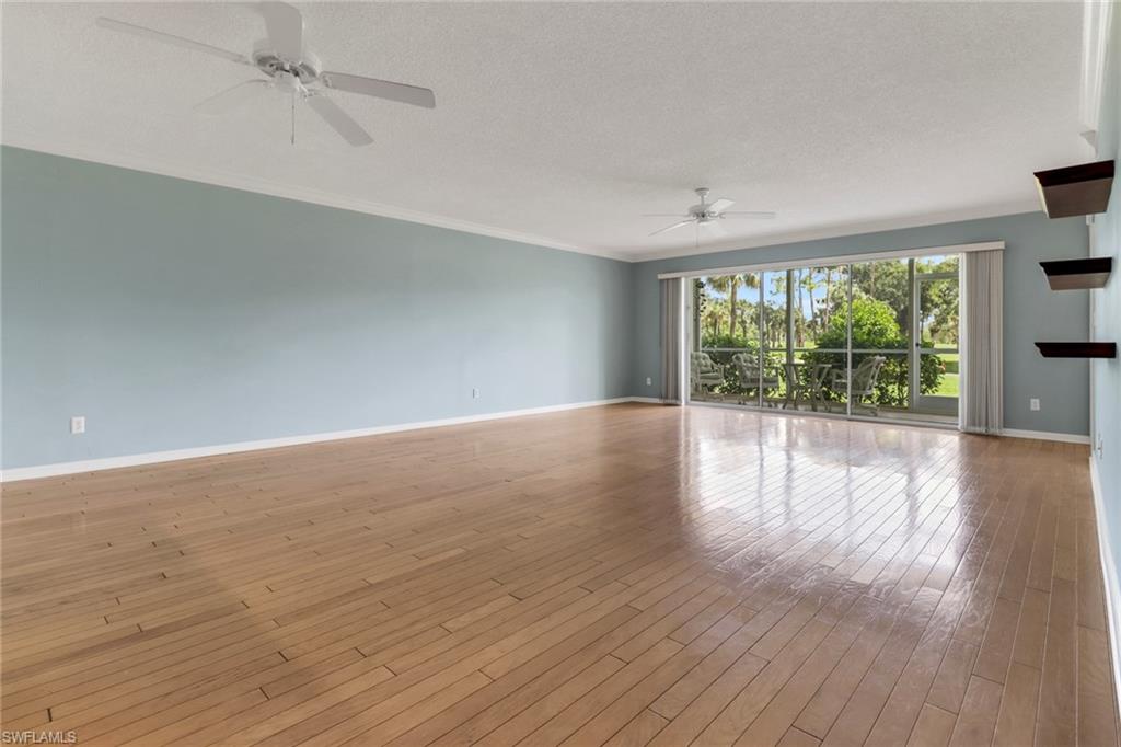 4556 Andover Way, Unit E106 Naples, FL 34112 - Photo 16 of 40 Unfurnished room featuring a ceiling fan, a textured ceiling, hardwood / wood-style flooring, and crown molding