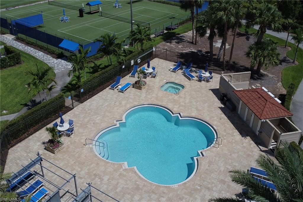 4556 Andover Way, Unit E106 Naples, FL 34112 - Photo 2 of 40 Community pool with a patio, a tennis court, and a hot tub
