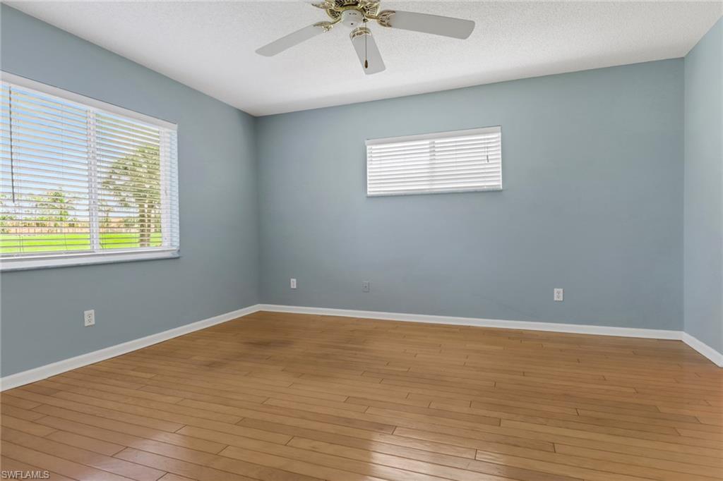 4556 Andover Way, Unit E106 Naples, FL 34112 - Photo 21 of 40 Spare room with healthy amount of natural light, ceiling fan, light wood-type flooring, and a textured ceiling