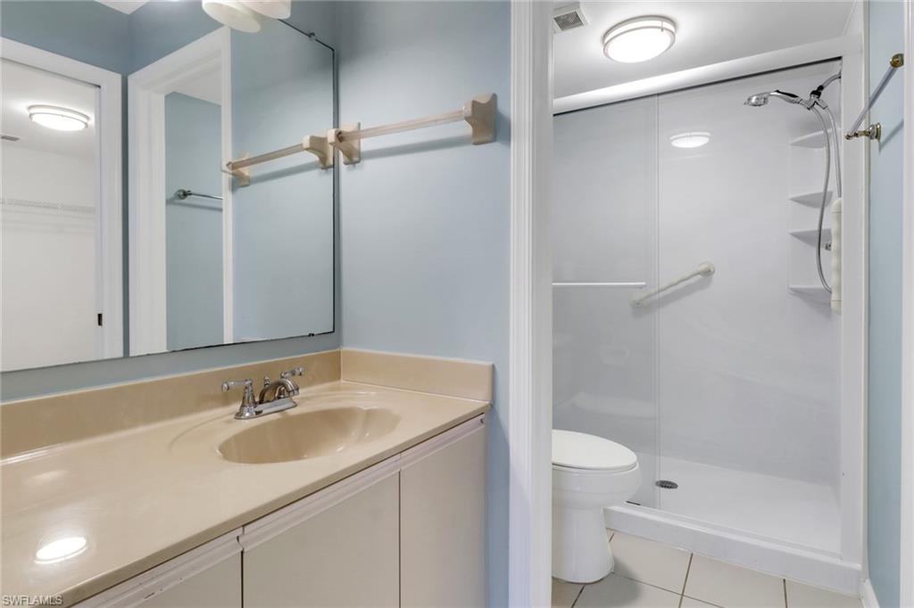 4556 Andover Way, Unit E106 Naples, FL 34112 - Photo 26 of 40 Full bath with vanity, a shower stall, light tile patterned floors, and a walk in closet