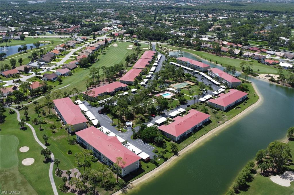 4556 Andover Way, Unit E106 Naples, FL 34112 - Photo 37 of 40 Aerial view of property and surrounding area featuring a golf course and a nearby body of water