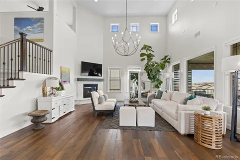 a living room with furniture a chandelier and a potted plant