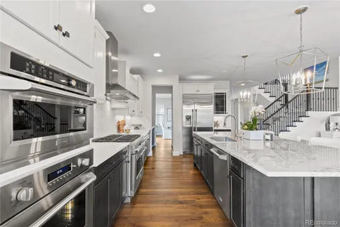 a large kitchen with stainless steel appliances kitchen island granite countertop a large island a stove a sink a refrigerator and a wooden cabinets