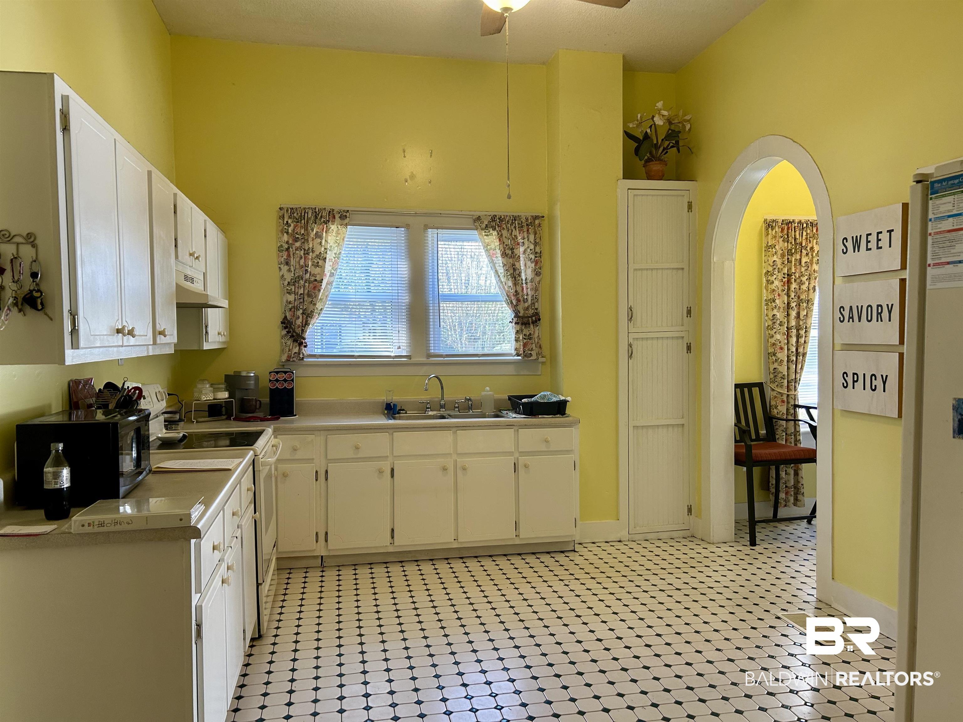 405 North Wasson Avenue Mobile, AL 36612 - Photo 10 of 26 Kitchen with light tile patterned flooring, white range oven, white cabinetry, and sink