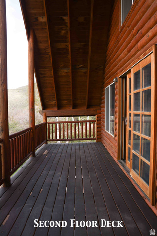 15253 Mill Road, Unit 62 Huntsville, UT 84317 - Photo 37 of 48 Spacious log-sided deck featuring dark-stained wood flooring, natural wood railings, and a wood-paneled ceiling