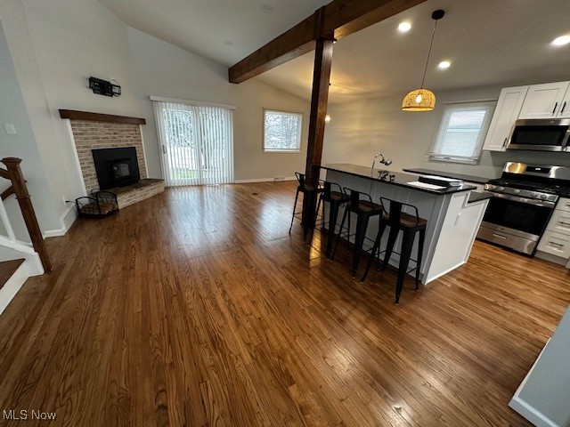 9109 Johnnycake Ridge Road Mentor, OH 44060 - Photo 27 of 28 Kitchen with open floor plan, a breakfast bar area, stainless steel appliances, white cabinetry, and dark wood-style floors