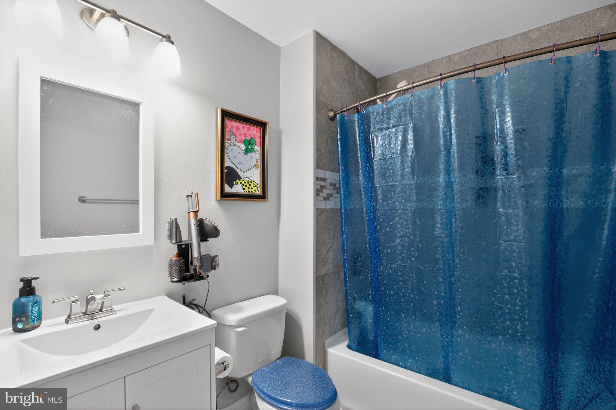 11789 Little Cove Point Road Lusby, MD 20657 - Photo 13 of 16 a bathroom with a sink a toilet and shower curtain