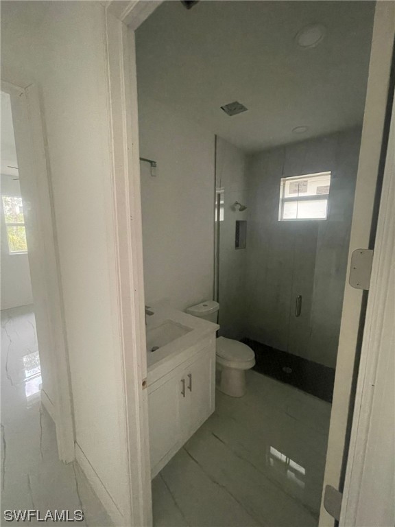 2524 39th Street West Lehigh Acres, FL 33971 - Photo 5 of 9 a bathroom with a granite countertop toilet a sink and a shower