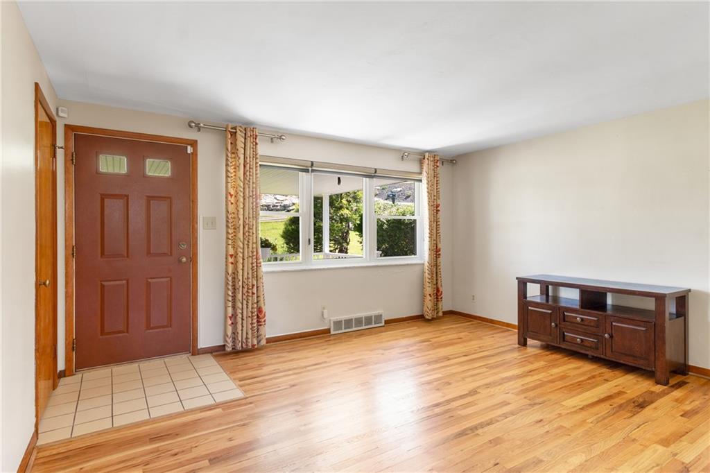 1017 Silver Lane McKees Rocks, PA 15136 - Photo 5 of 34 a view of an empty room with window and wooden floor
