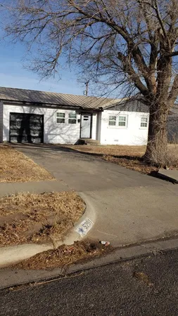 a front view of house with yard and trees in the background
