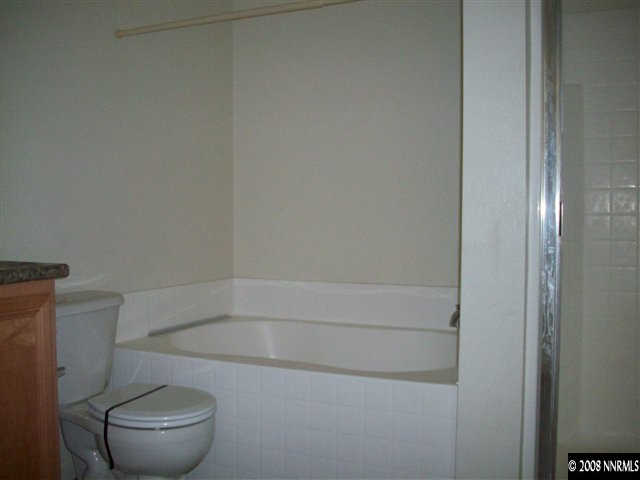 9275 Red Baron Boulevard Reno, NV 89506 - Photo 3 of 9 a white toilet sitting next to a bath tub