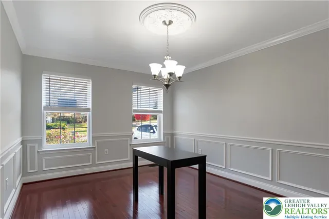a view of a dining room with furniture a chandelier and wooden floor