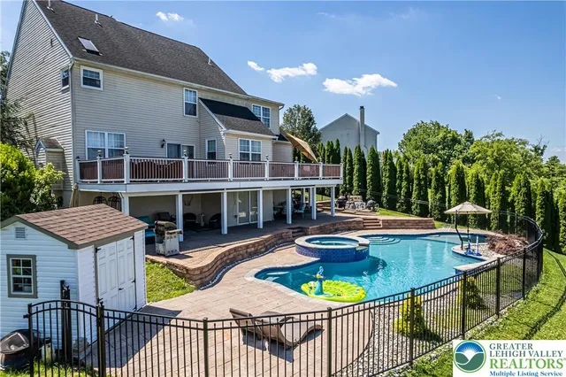 an aerial view of a house with a swimming pool and sitting area