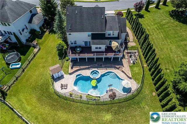 a front view of a house with swimming pool table and chairs