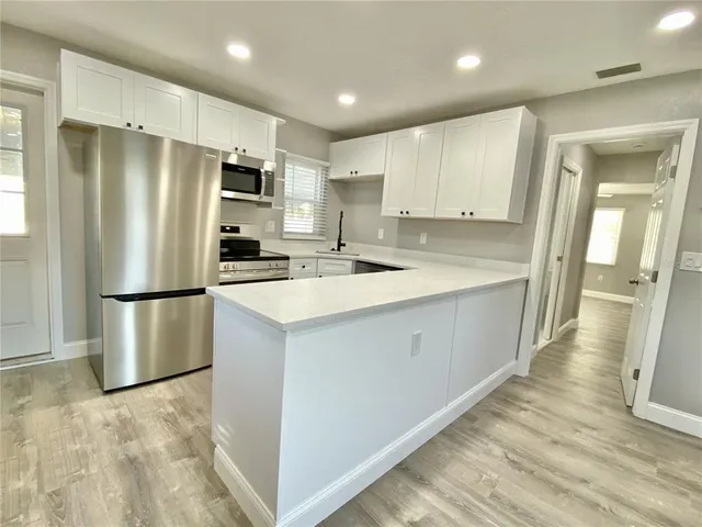 a kitchen with stainless steel appliances a refrigerator and a stove top oven