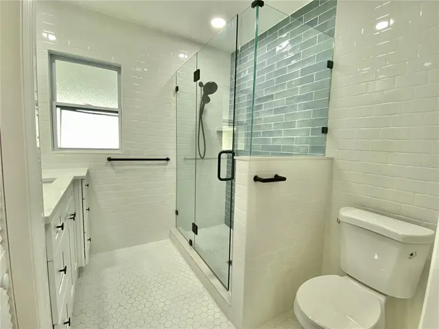 a bathroom with a granite countertop toilet sink and shower